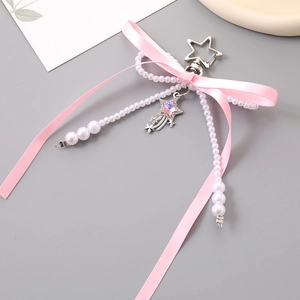 Detail of pink bow ribbon keychain with faux pearls and sparkling star charm