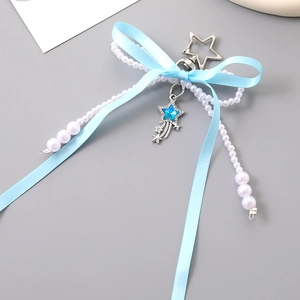 Close-up of blue ribbon bow with faux pearl beads and star charm pendant for bags