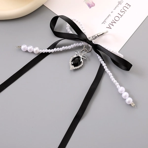 Detail of vintage black satin double bow keychain with pearls and heart stone pendant