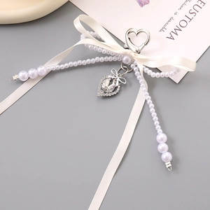 Elegant double bow keychain with faux pearls and heart pendant on a stylish gray background