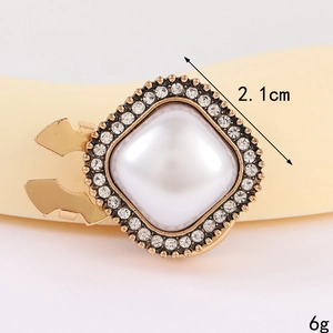 Makro-Detail der 2,1 cm quadratischen Goldbrosche mit Perle und Kristallumrandung