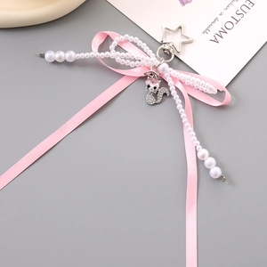 Detail of pink silk bow keychain with pearl string and rhinestone cat pendant
