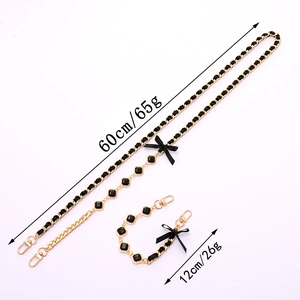 Elegant gold chain accessory with black ribbon bows and gems for bags and phones