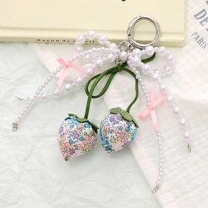 Detail of fabric strawberry pendant with pearl bow and silver lobster clasp