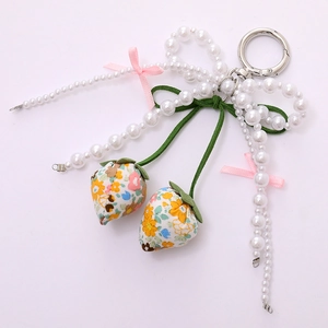 Detail of floral strawberry charms and pearls on a sweet pastoral style keychain