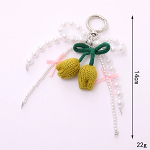 Handmade knitted yellow tulip bag charm with white pearls and pink ribbon bow detail
