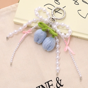 Handmade knitted tulip bag charm with pearl bow and blue floral crochet details