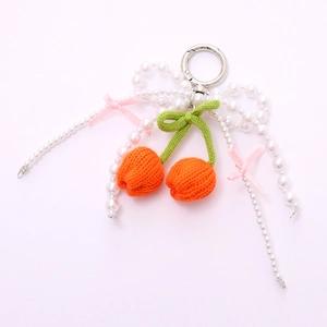 Knitted tulip bag charm with orange flowers, white pearls, and a metal keychain ring