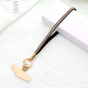Detail of luxury black leather phone strap with double-row rhinestones and gold clasp