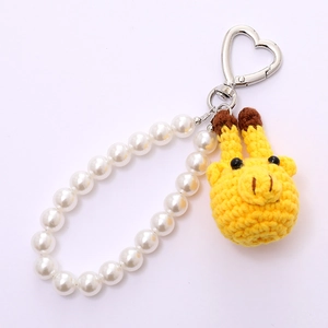 Handmade crochet giraffe keychain with white pearls and heart-shaped metal clasp