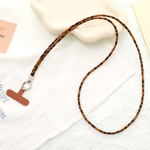 Detailed view of leopard print leather phone lanyard with metal ring and T-shaped patch