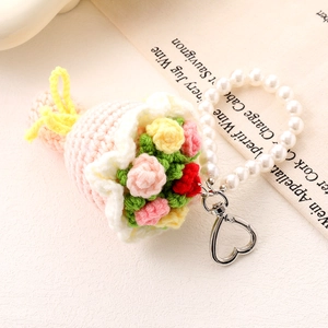 Close-up of handmade crochet flower bouquet pendant with pearls and heart metal clasp