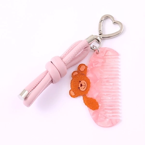 Pink PU leather bow phone charm with cat comb pendant and sparkling orange bear