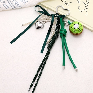 Handmade crochet kiwi bag charm with green bow, pearl chain and leather lanyard