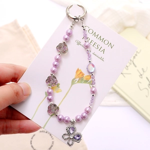 Purple beaded phone strap with floral charms and a butterfly pendant on a card