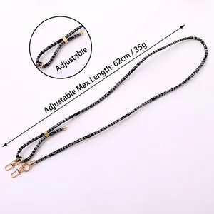Adjustable black and white geometric woven crossbody phone strap with gold metal buckle