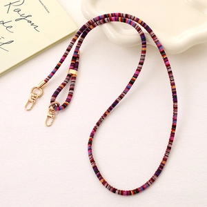 Detail of colorful woven strap with golden metal lobster clasps and ethnic stripe pattern