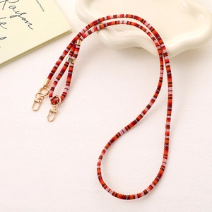 Detail of colorful woven phone strap with golden lobster clasp and striped pattern