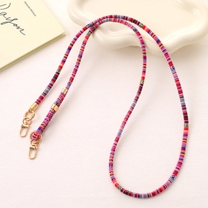 Detailed shot of ethnic woven phone strap with colorful patterns and gold spring buckles
