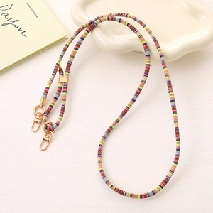 Ethnic style colorful braided lanyard with gold lobster clasps on a cream tray
