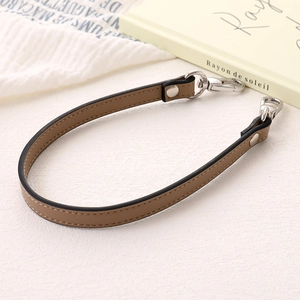 Detail of a brown PU leather wrist strap with high-quality silver lobster clasp for handbags