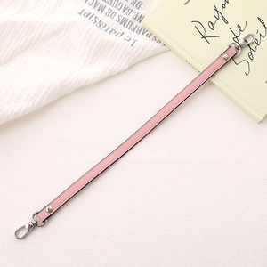 Pink PU leather phone strap with silver dual lobster clasps in a lifestyle setting
