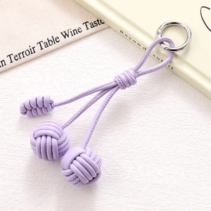 Detail of purple woven leather cord key ring with round sphere knots and silver metal clasp