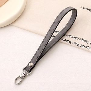 Close-up of grey leather wrist strap with silver rivet and polished lobster clasp