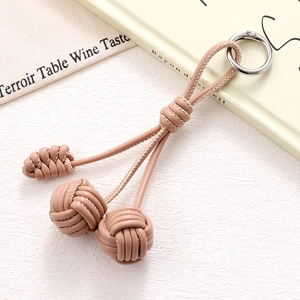Detail of pink PU leather woven phone strap with silver ring and stylish spherical knots
