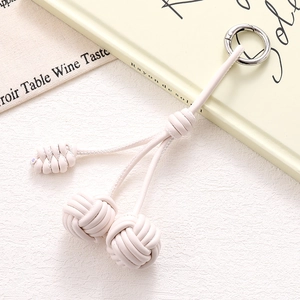 Detail of cream-white woven PU leather double ball charm with silver metal ring clasp