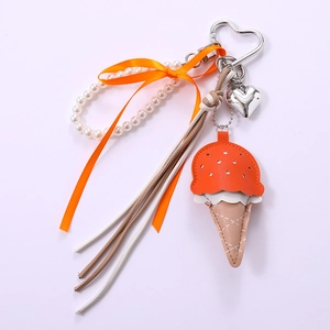 Detail of leather ice cream charm with orange ribbon bow and white pearl strand