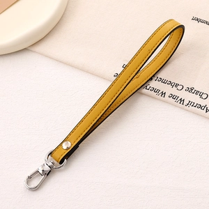 Detail of a bright yellow leather wrist strap with a silver swivel metal spring clasp