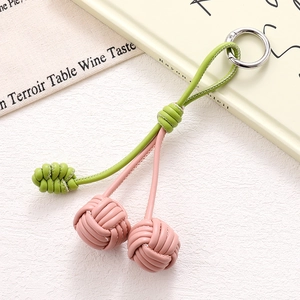 Detailed view of handmade pink leather cherry charm with braided cord and silver ring