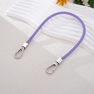 Detail of hand-woven purple leather strap with silver lobster clasps on wave stand