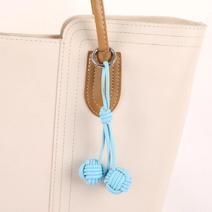 Handmade woven double blue ball pendant on beige leather tote bag with silver ring