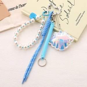 Detail of blue bow beaded phone charm with laser shell pendant and metal hardware