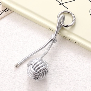 Detail of silver PU leather braided ball bag charm with round spring clasp hook