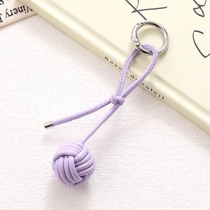 Detail of a purple woven leather ball keychain with a round metal spring clip
