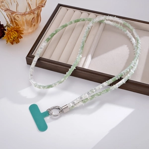 Detail of green sequined denim phone lanyard with silver metal clip on wooden display