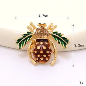 Macro shot showing dimensions of bee brooch with green enamel wings and brown rhinestones