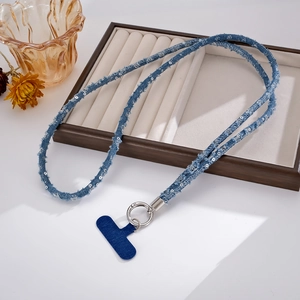 Detail of blue sequined denim crossbody phone strap with fringe and metal spring ring