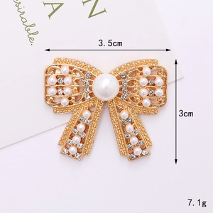 Vue détaillée d'une broche nœud avec perle et strass présentant les mesures précises