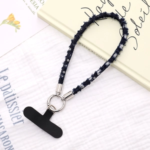 Dettaglio del cinturino da polso in denim con paillettes, anello d'argento e gancio