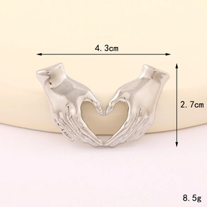 Silver alloy heart-shaped hand gesture brooch with detailed artistic design