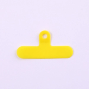 Detail of a bright yellow PVC phone lanyard tether tab with a single metal ring hole