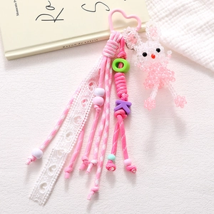 Detail of pink acrylic bunny charm with beaded rope and lace ribbon for bags