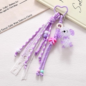 Detail of purple beaded poodle keychain with heart hook and woven tassel accessory