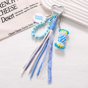 Macro view of handmade candy bag charm with blue ribbons and pearlescent beads