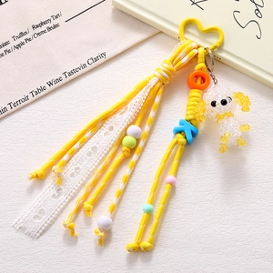 Macro shot of handmade yellow acrylic beaded puppy charm with lace and heart buckle