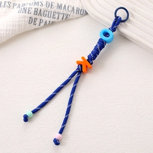 Détail d'un porte-clés en nylon tressé bleu et blanc avec des perles de lettres OK colorées
